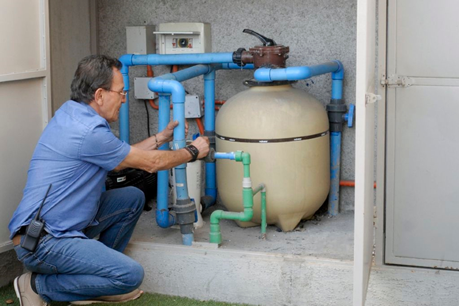 Técnico revisando bomba y filtro de piscina